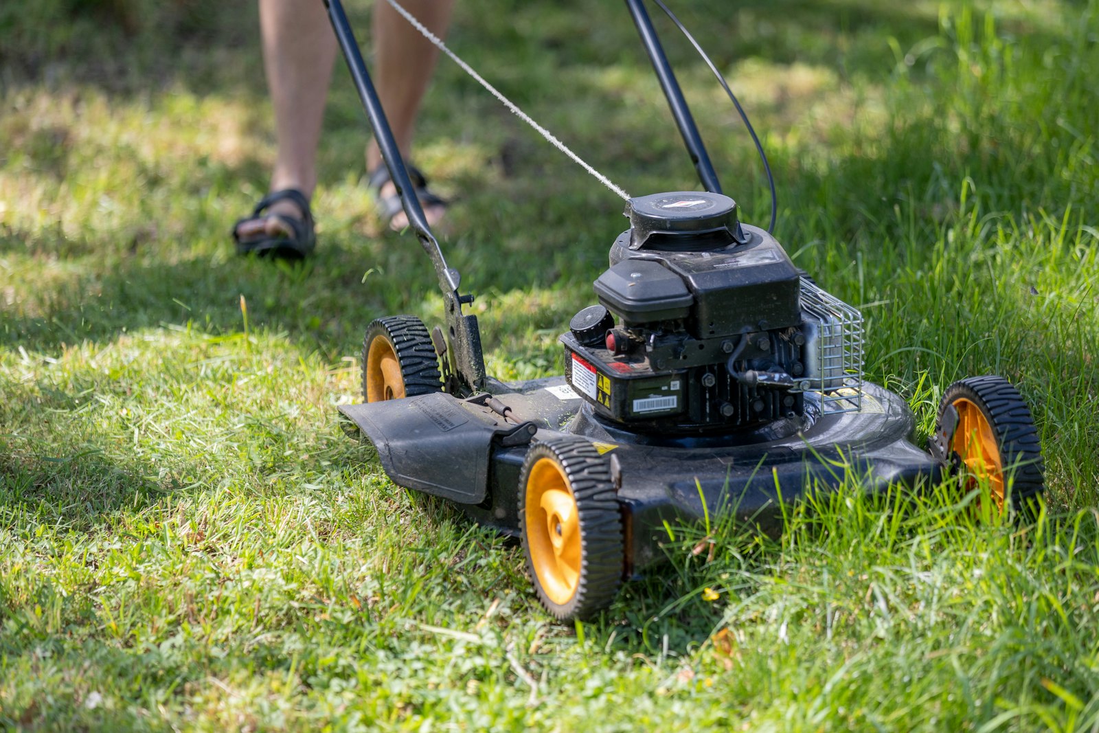 A lawn being mowed neatly on a sunny day